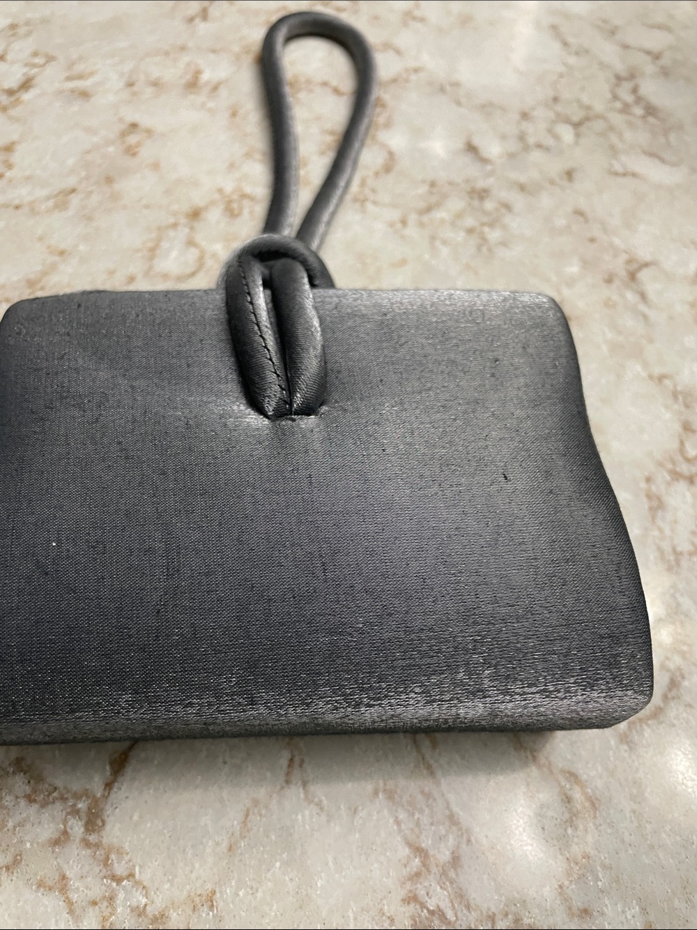 Gray cocktail bag with straps and a rope tie handle . Elegant evening bag .